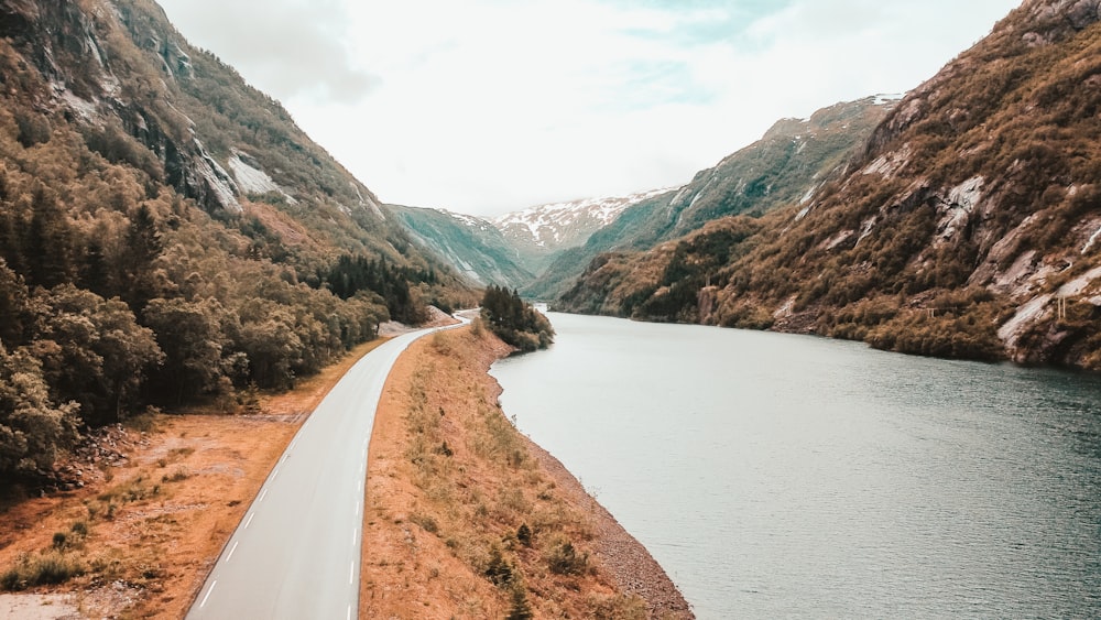 strada sterrata marrone vicino al lago durante il giorno