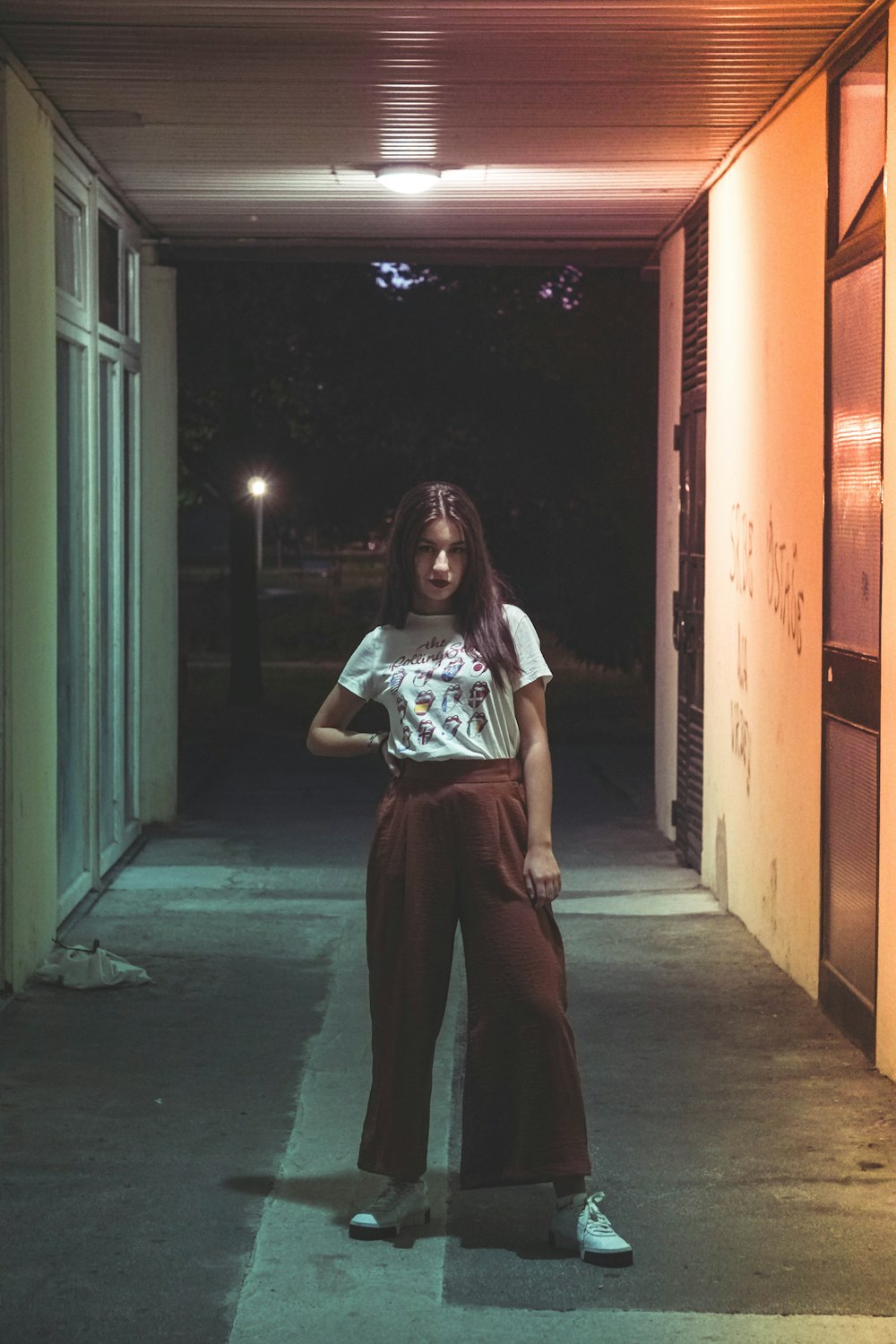 woman in gray t-shirt and brown pants standing near door