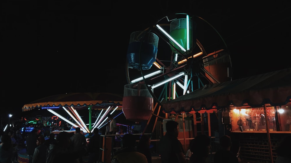 people standing near green and red lighted building during nighttime