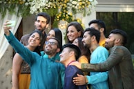 A joyful group photo of friends smiling and posing at a festive gathering.