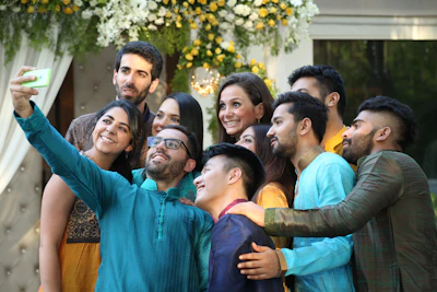 Group selfie in front of 90s-themed decorations with bright neon colors and smiley faces.