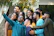 Group of friends laughing and posing together in front of a colorful digital selfie booth.