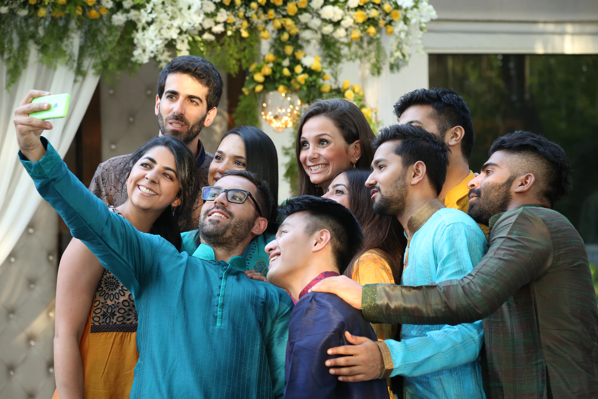 A group of friends taking a cheerful selfie at a local art fair, surrounded by colorful booths.