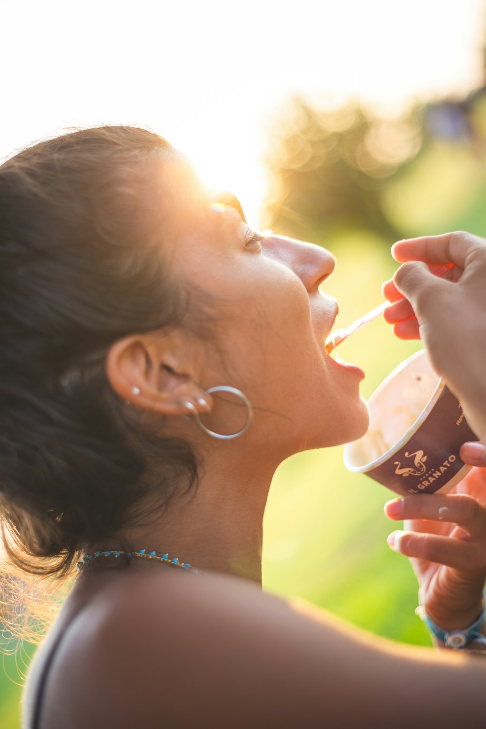 woman in white pearl earrings holding red and white cup