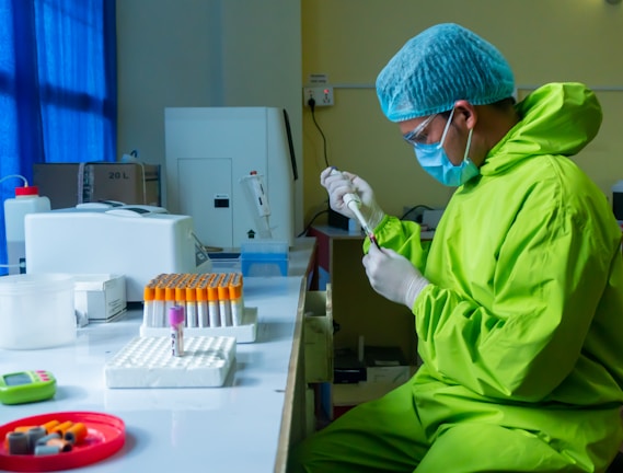 man in green scrub suit holding white plastic tube