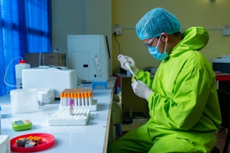Technician in protective gear conducting chemical testing in a modern lab.