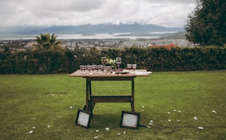 A beautifully crafted wooden dining table set in a serene garden.
