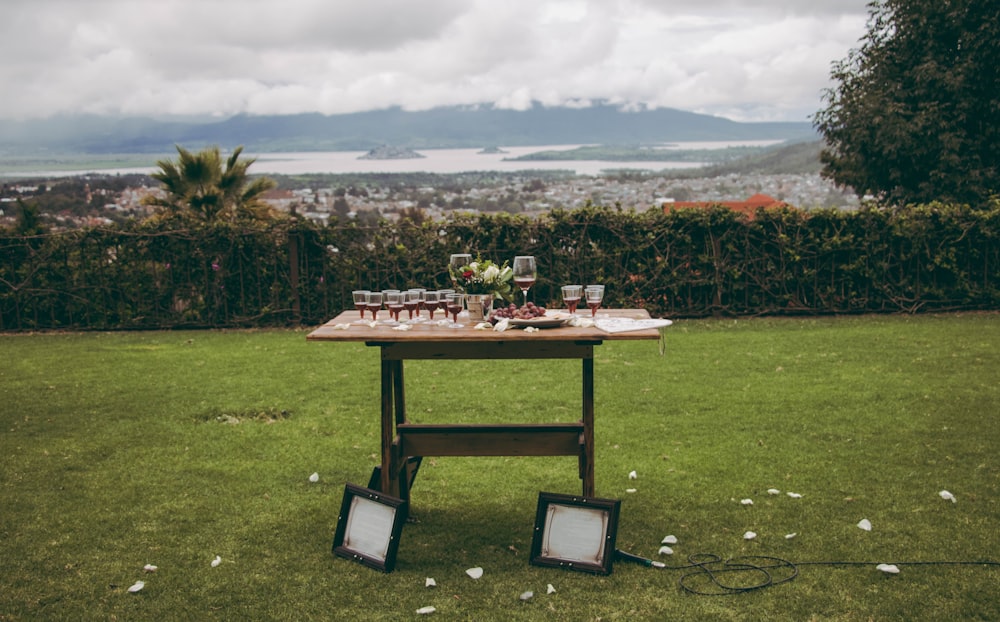 brown wooden table on green grass field during daytime