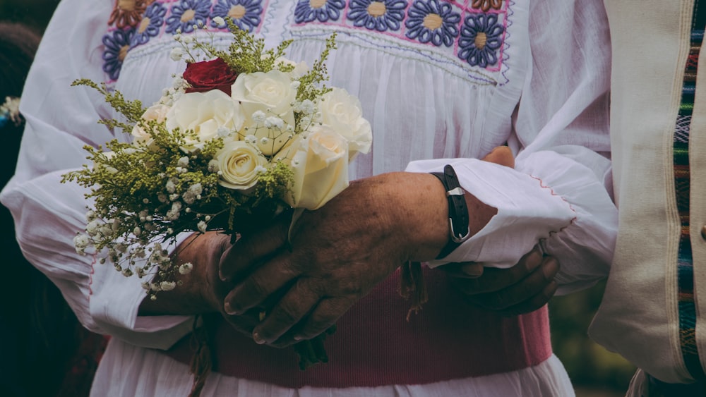 person holding bouquet of yellow roses