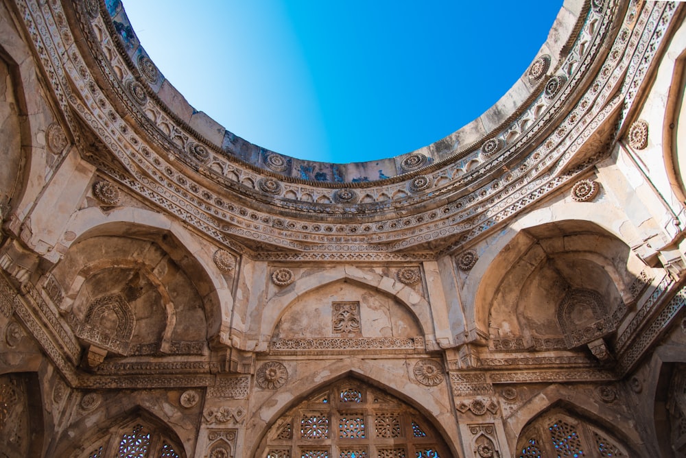 low angle photography of brown concrete building under blue sky during daytime