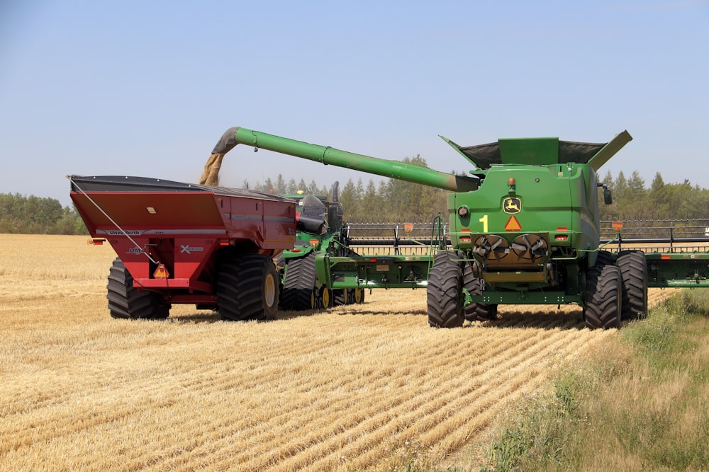 rotes und grünes schweres Gerät tagsüber auf braunem Feld