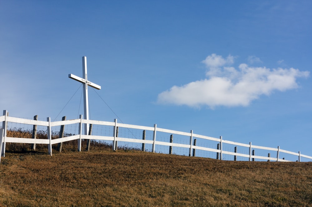 white wind turbines on brown grass field under blue and white sunny cloudy sky during daytime