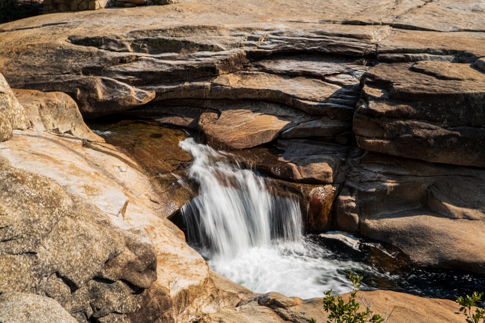 brown rock formation with water falls