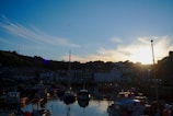 Sunset over a peaceful fishing village with boats docked.