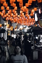 A bustling night market scene filled with colorful lanterns and locals enjoying street food.