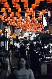 A bustling night market scene filled with colorful lanterns and locals enjoying street food.