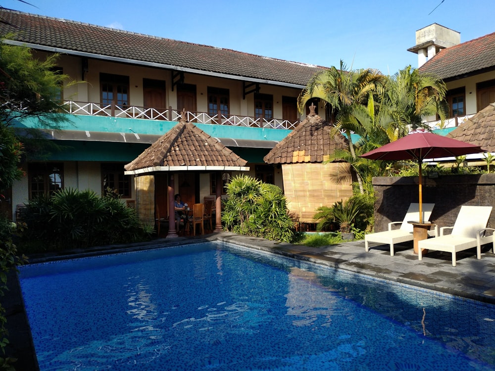 brown and white concrete house near swimming pool during daytime