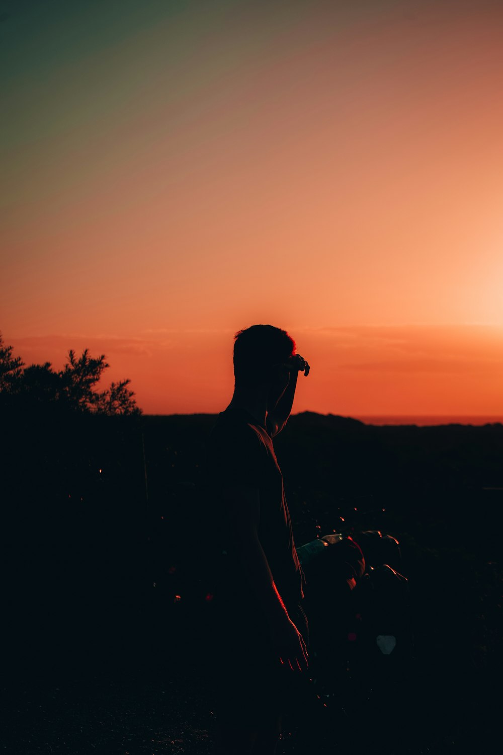 silhouette of man wearing sunglasses and cap during sunset