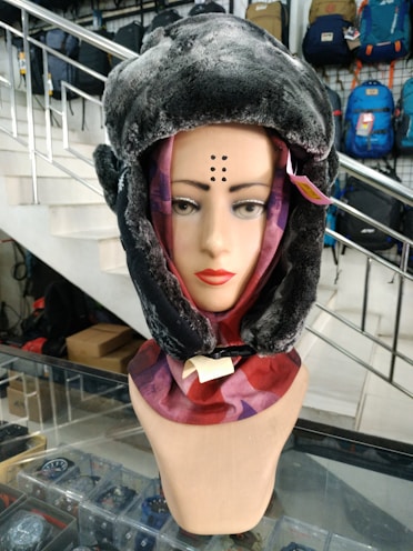 A selection of trendy hats and scarves displayed on mannequins.