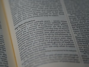 A close-up of an open book displaying a section titled 'The Year of Jubilee', with clear, focused text in the middle surrounded by other text in slightly blurred view.