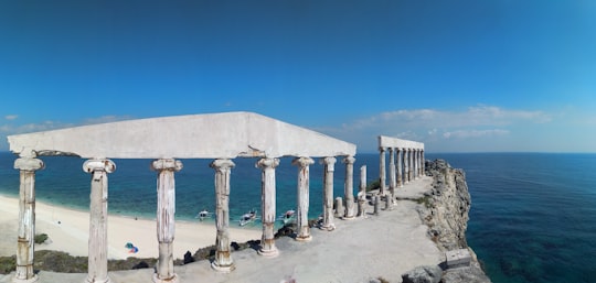 white concrete posts on brown sand under blue sky during daytime in Fortune Island Philippines