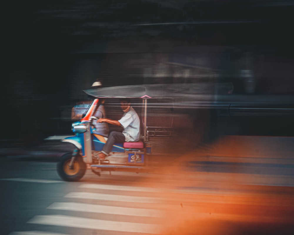 man in white shirt riding blue and white trike