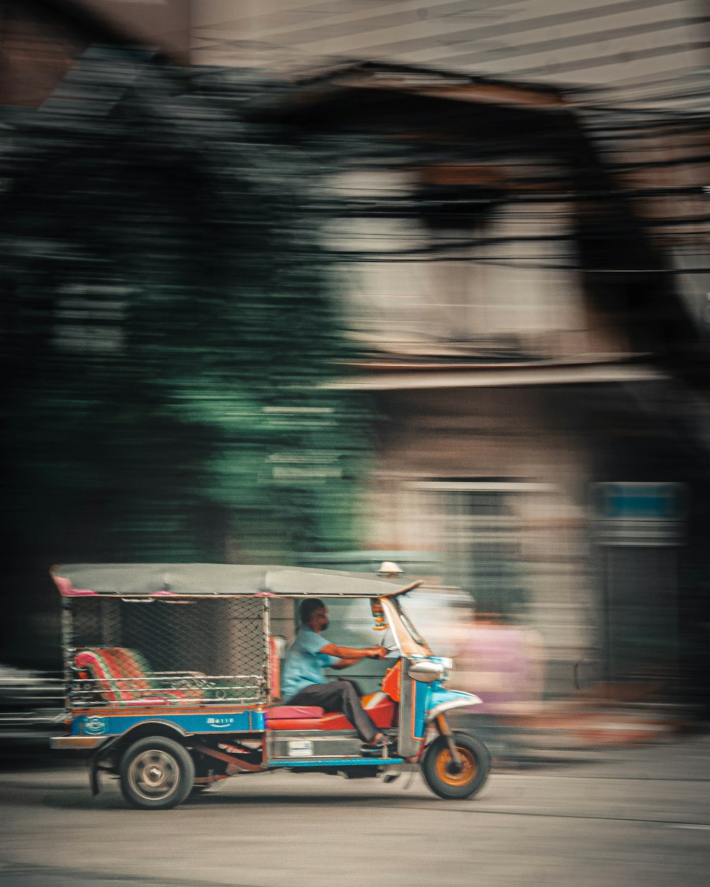 people riding on red and white auto rickshaw on road during daytime