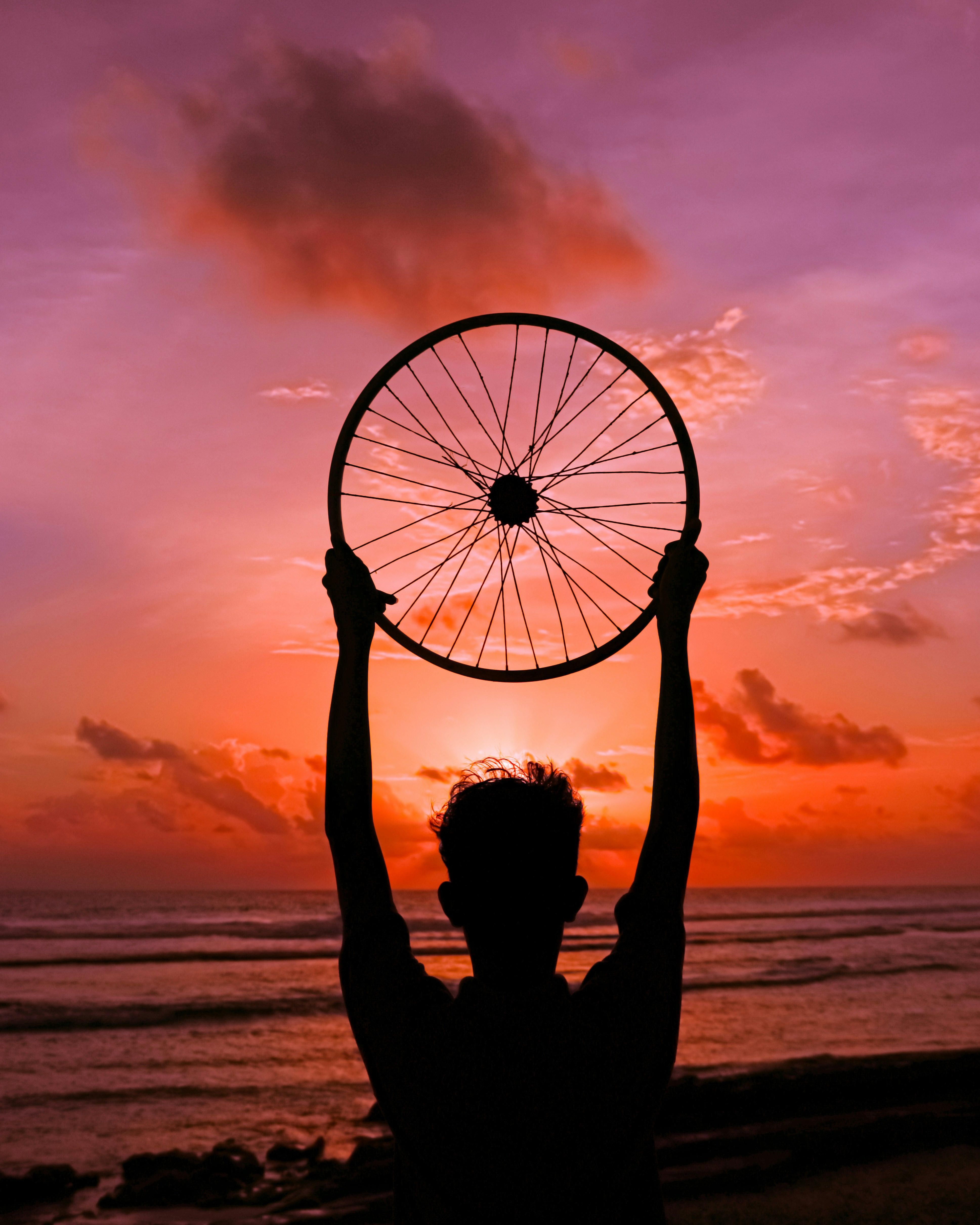 silhouette of person holding on the beach during sunset