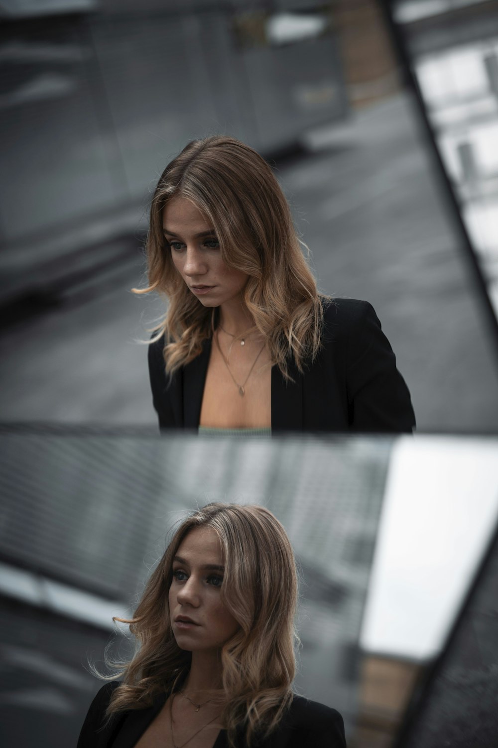 woman in black blazer standing near white wall