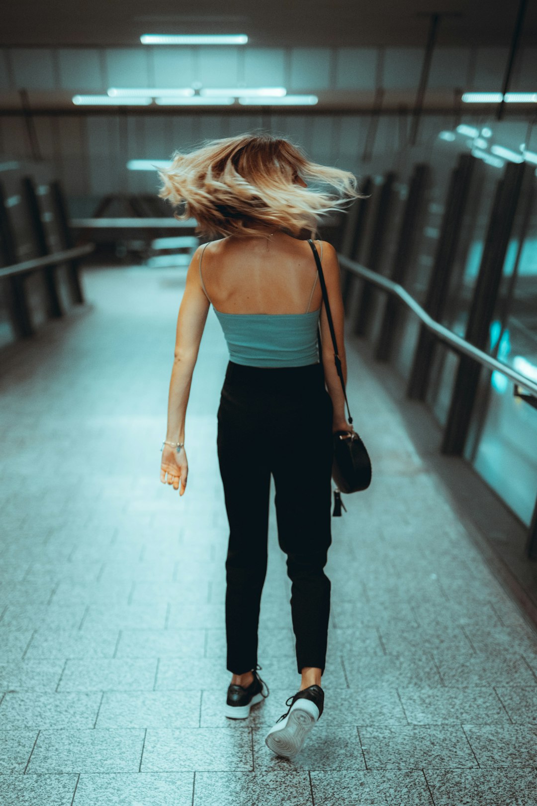 woman in black spaghetti strap top and black pants standing on hallway