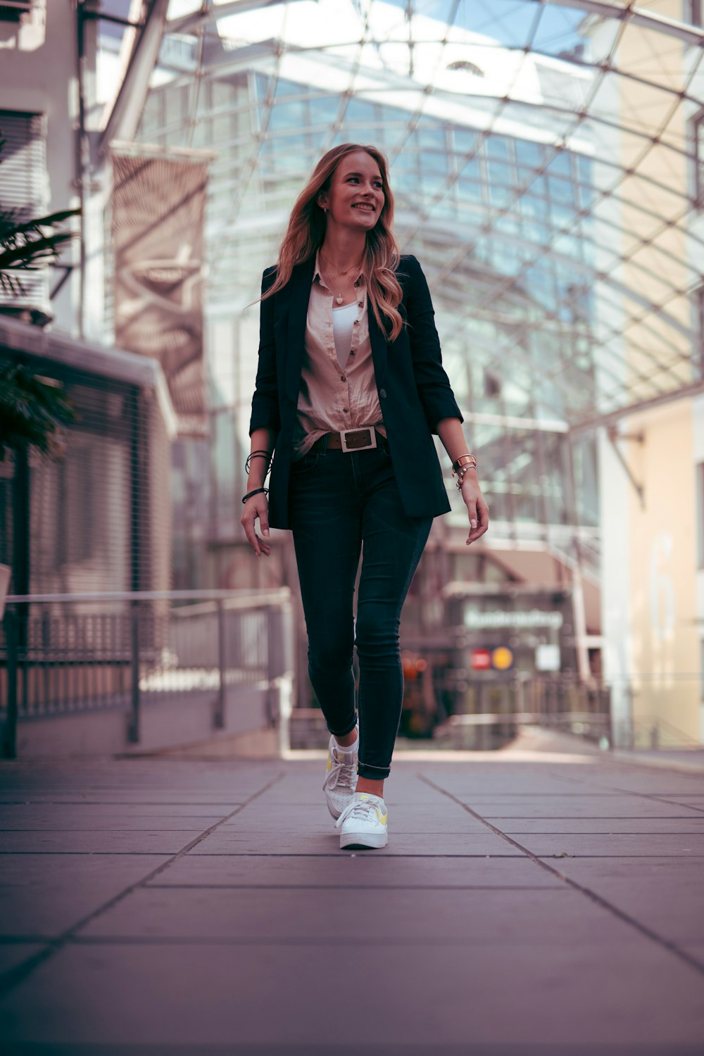 woman in black leather jacket and black pants standing on gray concrete floor during daytime