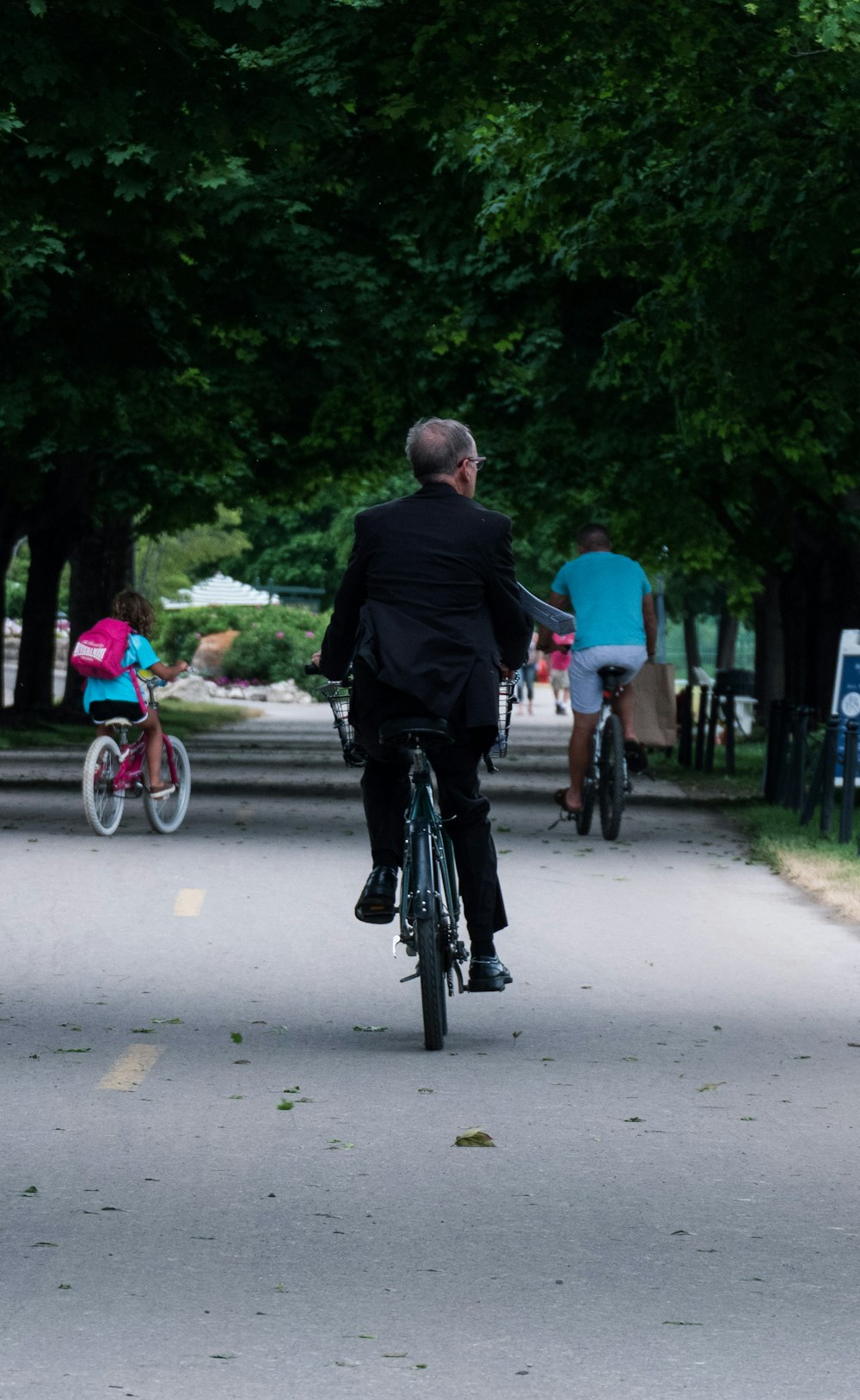 man in black jacket riding bicycle on road during daytime