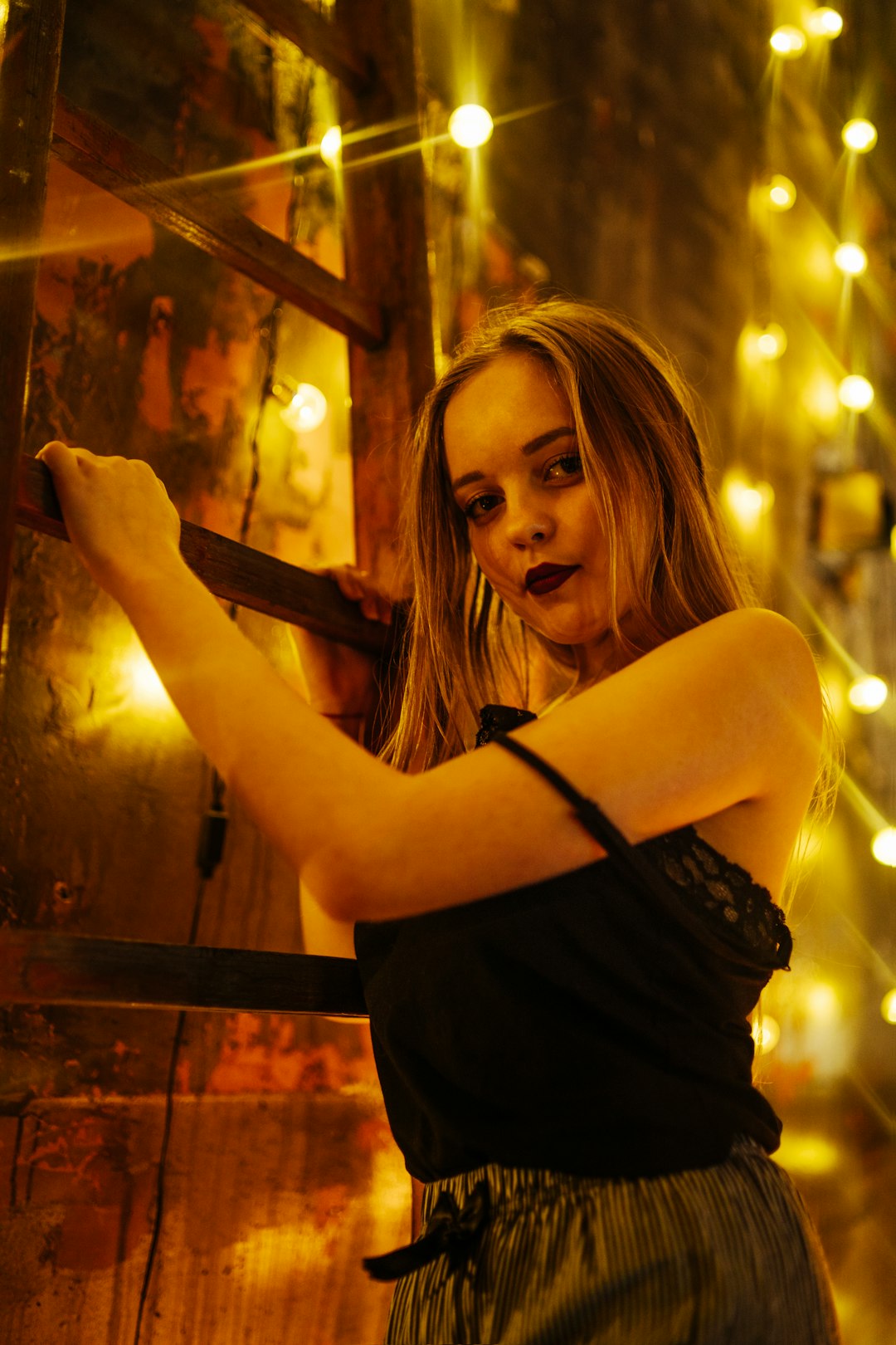 woman in black tank top holding brown wooden bar