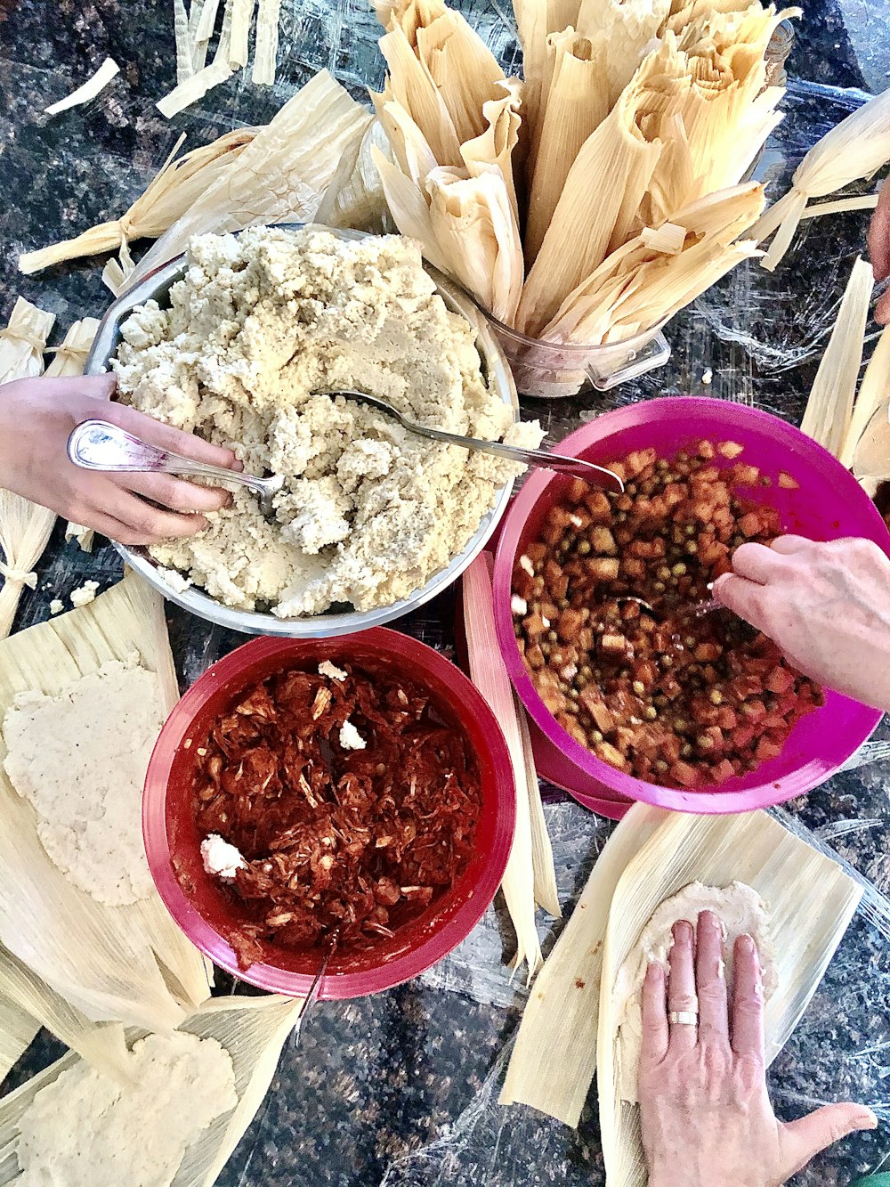 person holding red ceramic bowl with food