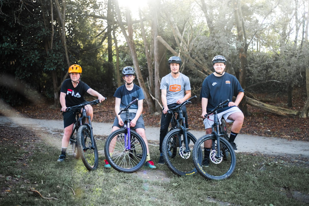 group of men riding bicycle on forest during daytime