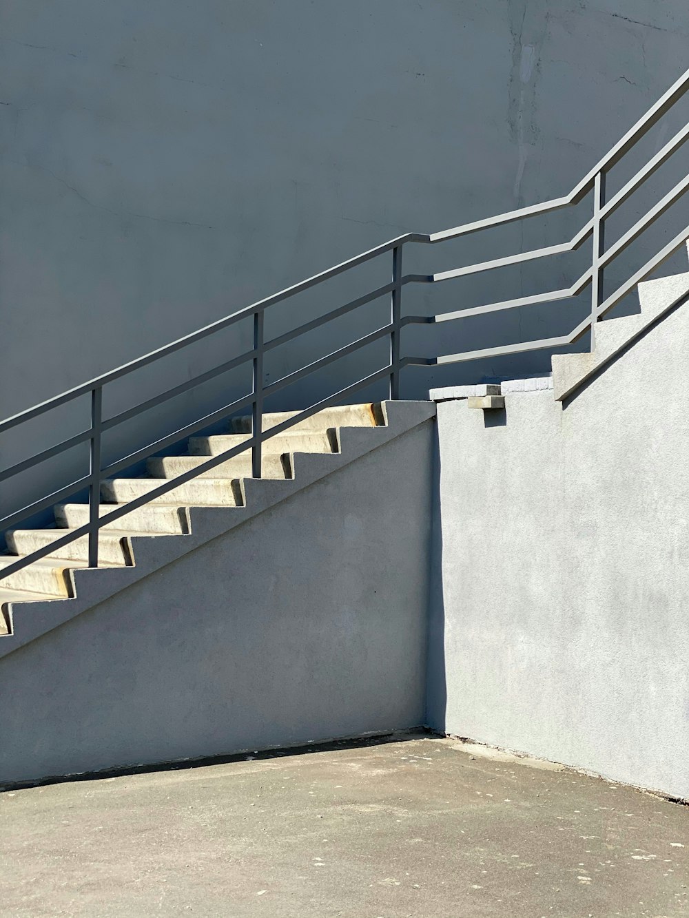 white concrete staircase with stainless steel railings