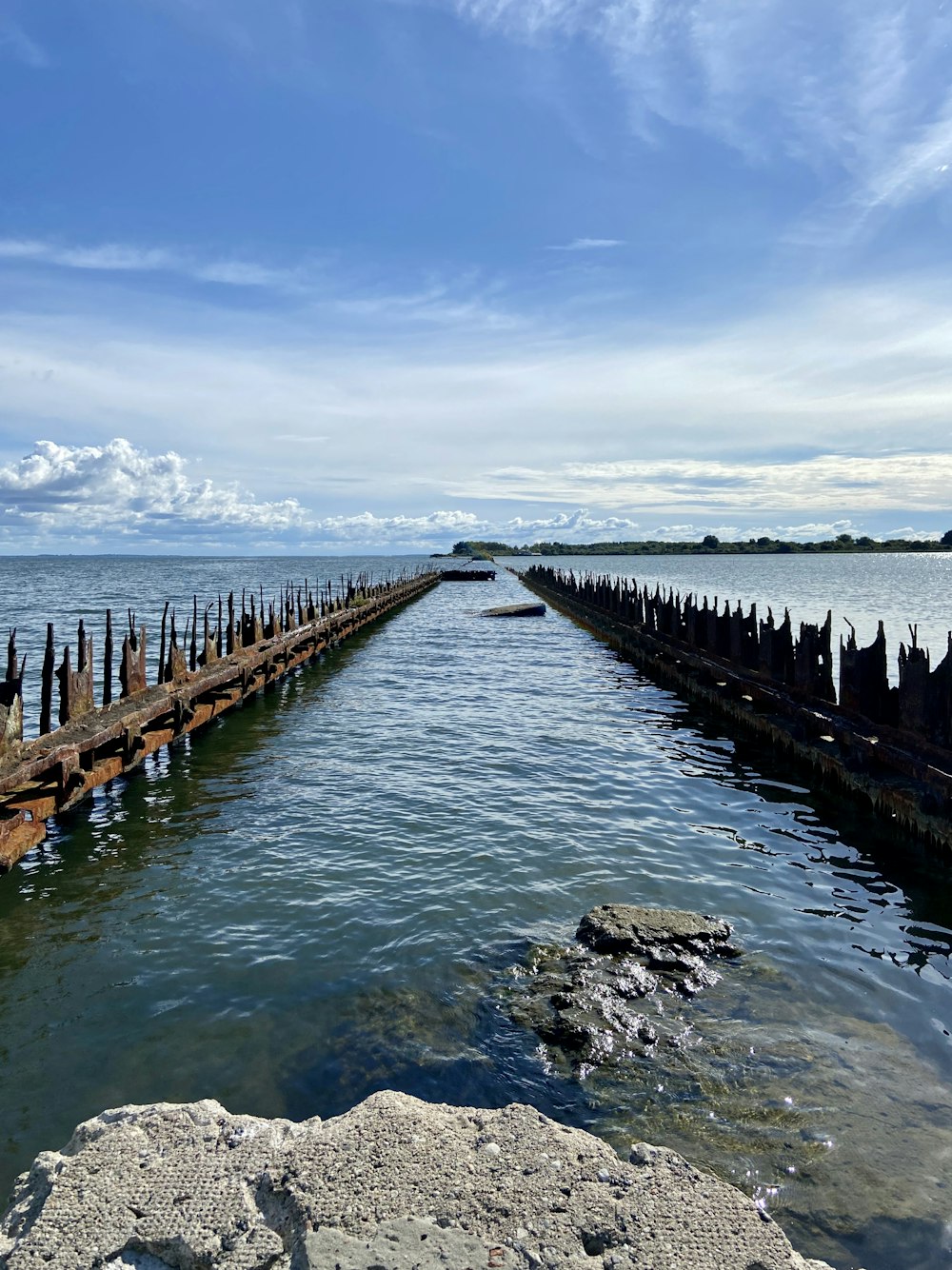 brown wooden dock on sea under blue sky during daytime