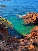 brown rock formation on body of water during daytime