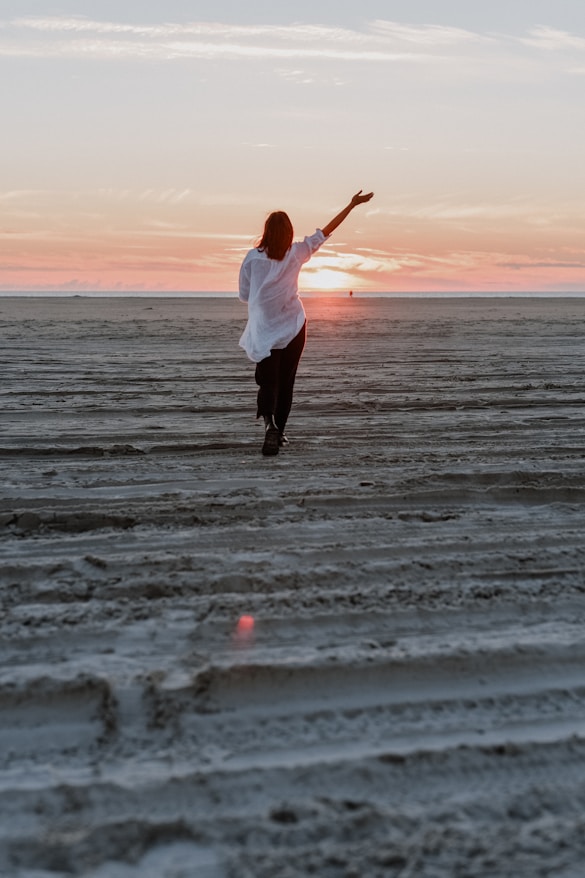 a woman standing on top of a sandy beach
