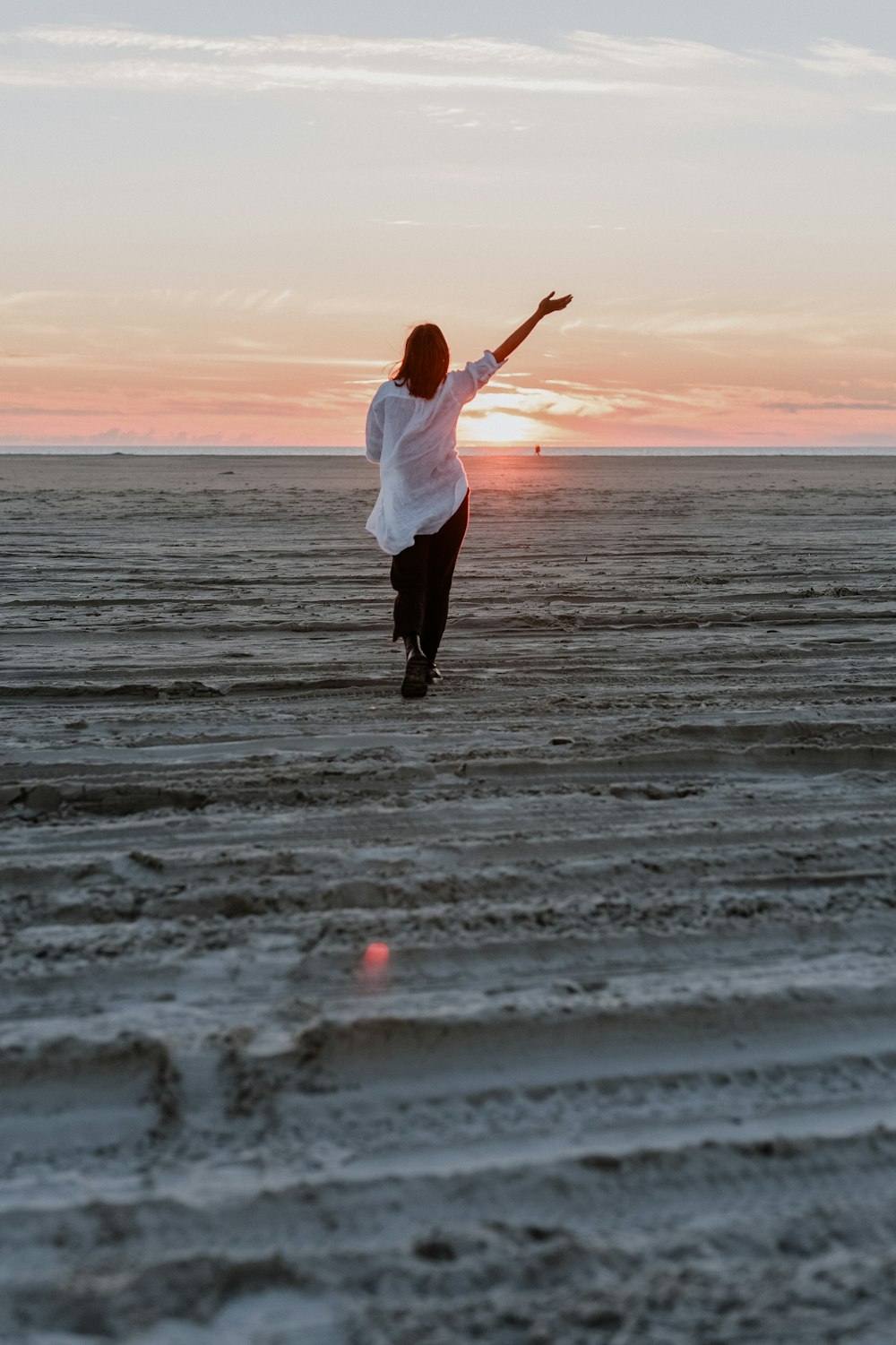 a woman standing on top of a sandy beach