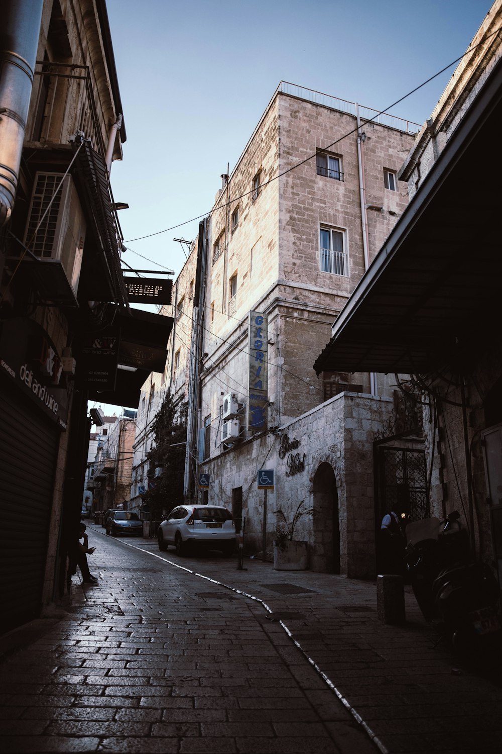 a narrow street with cars parked on the side of it