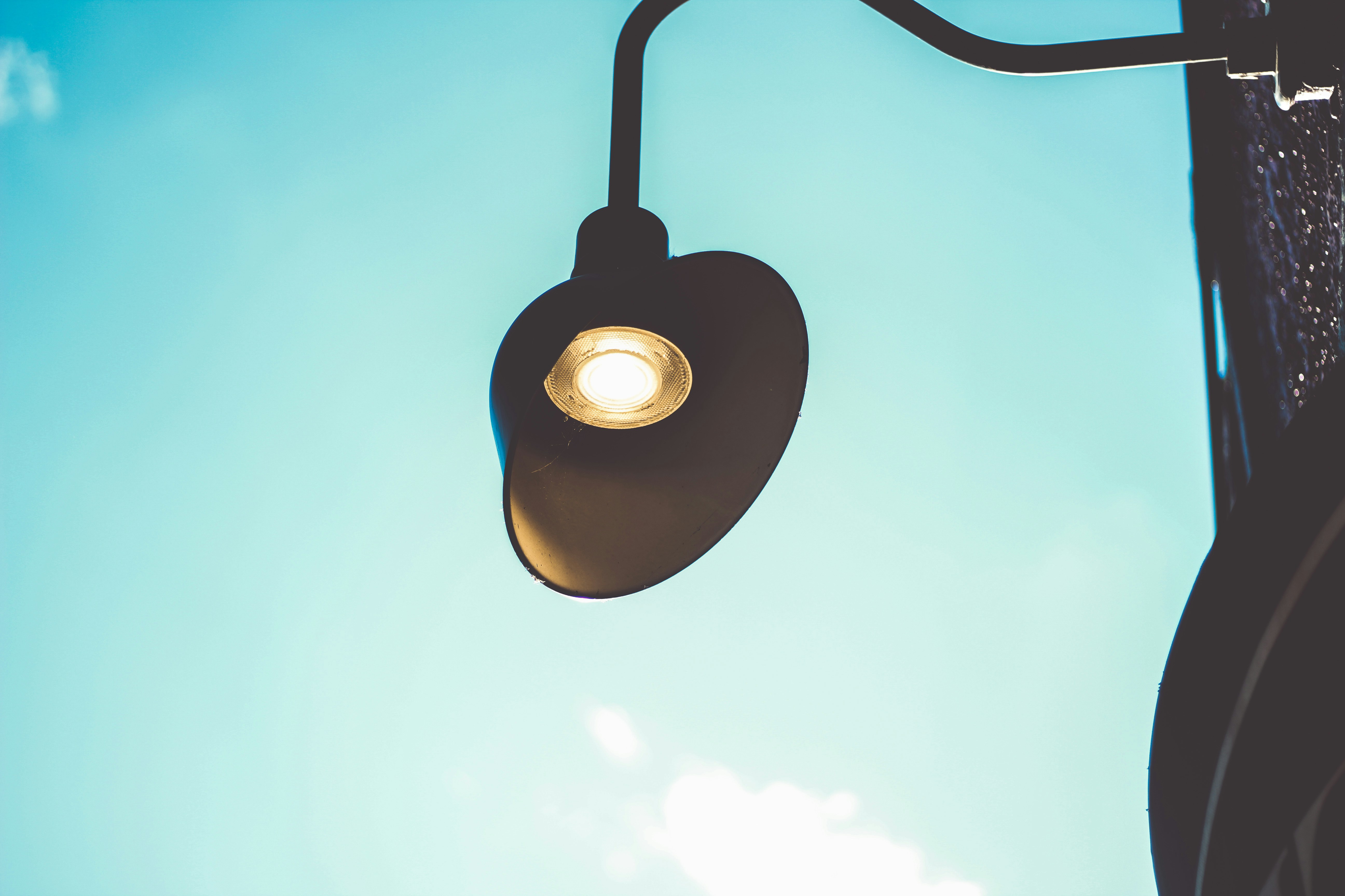 black pendant lamp turned on during daytime