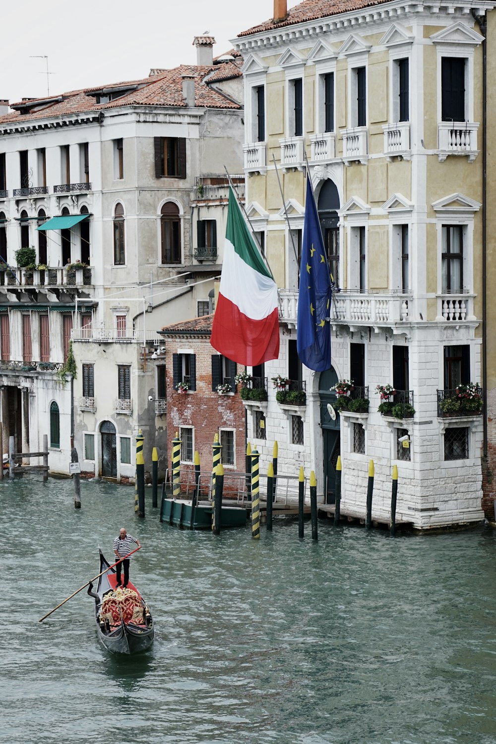 man in red shirt riding boat on river during daytime