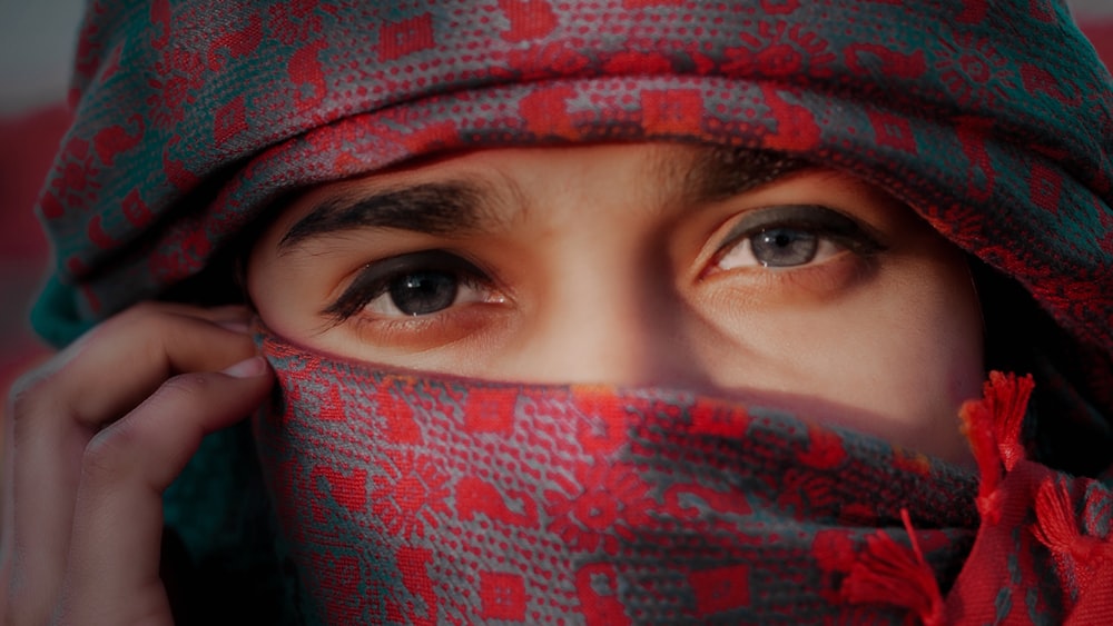 person covering face with red and white textile