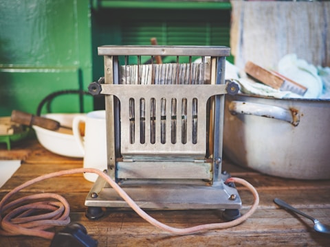 Close-up of a vintage-style toaster gleaming on a rustic wooden countertop.
