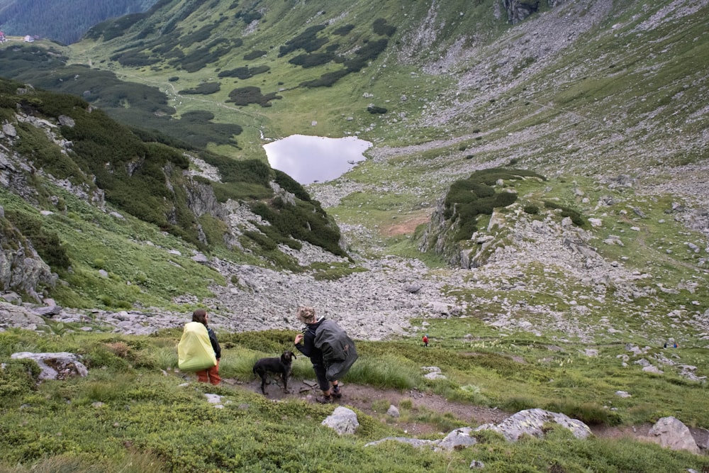 people on green grass field near mountains during daytime