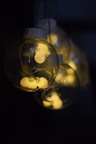 clear glass light bulb turned on in dark room