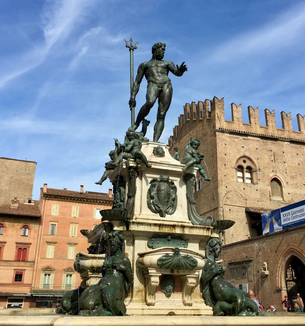 Statue d’homme à cheval près d’un bâtiment en béton brun pendant la journée