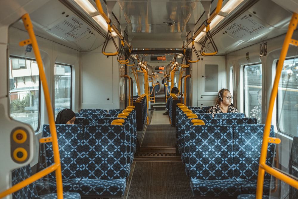 woman in gray jacket sitting on blue and yellow bus seat