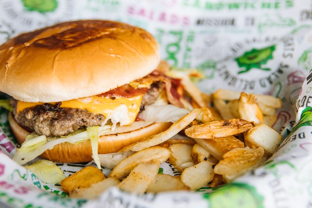 Hamburguesa con patatas fritas sobre papel blanco